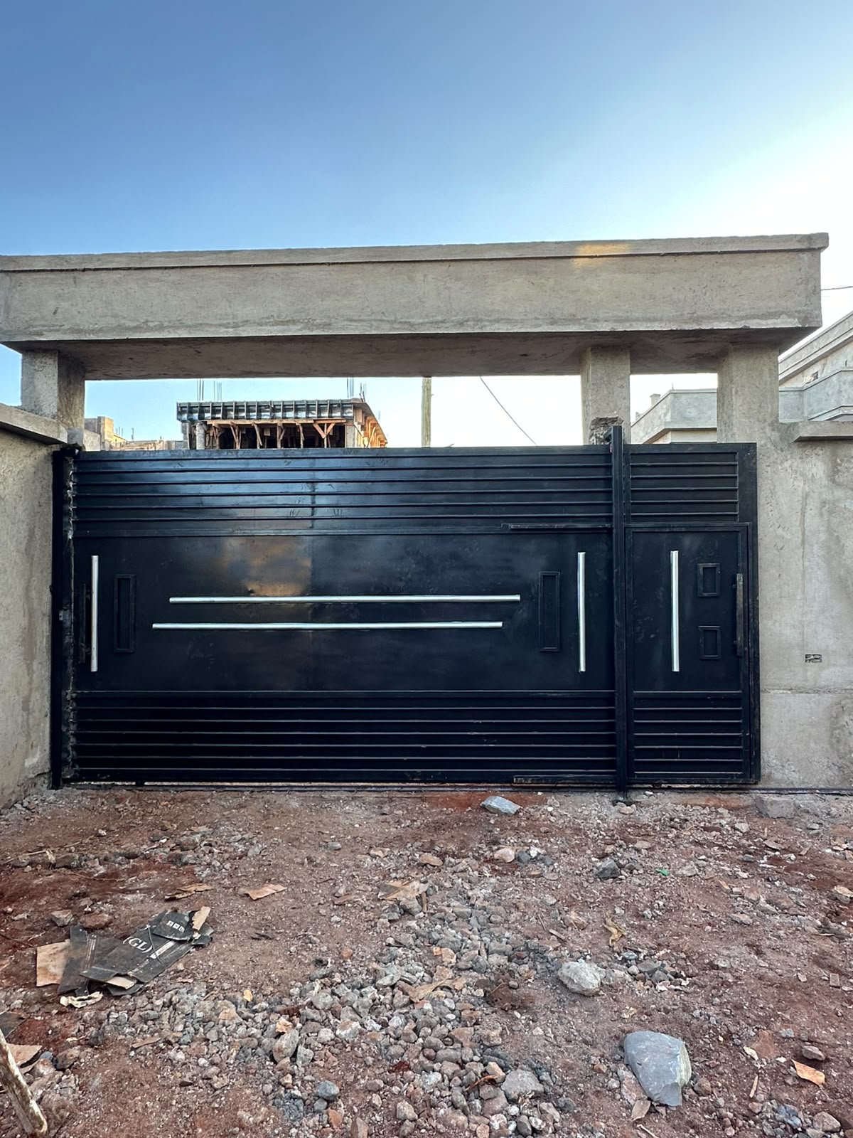 Modern black slatted gate with chrome accent bars